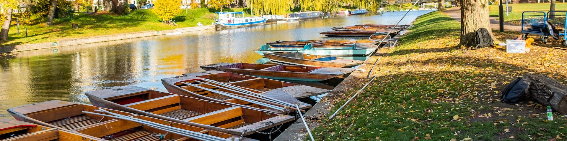 Traditional wooden punts moored along the River Cam in Jesus Green on a sunny autumn day