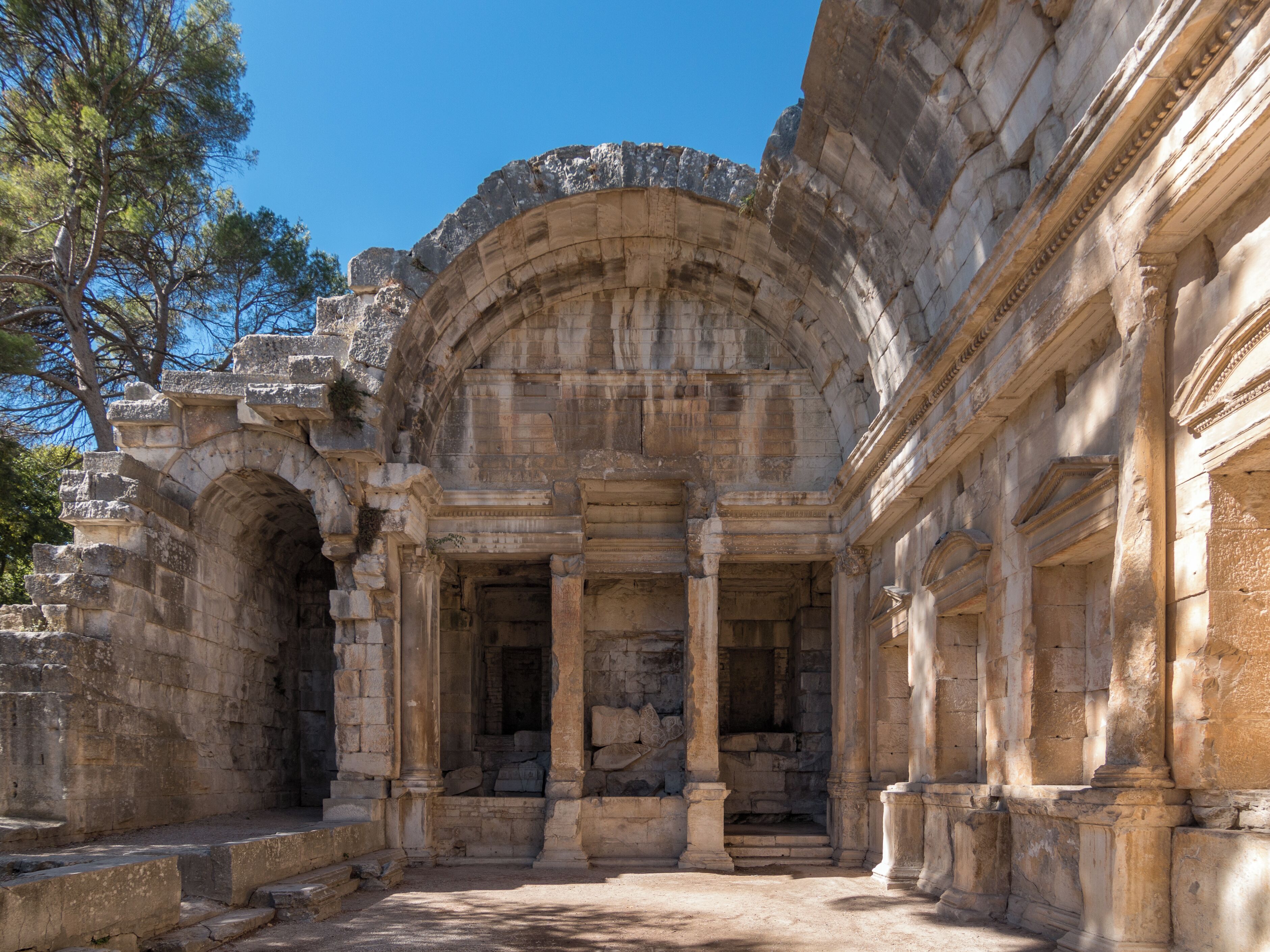 An ancient stone structure with columns and an arched entrance.