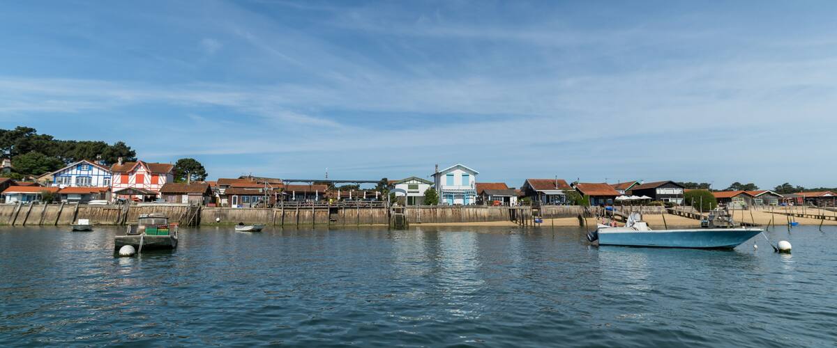 A coastal town with houses, boats, and a wooden pier.