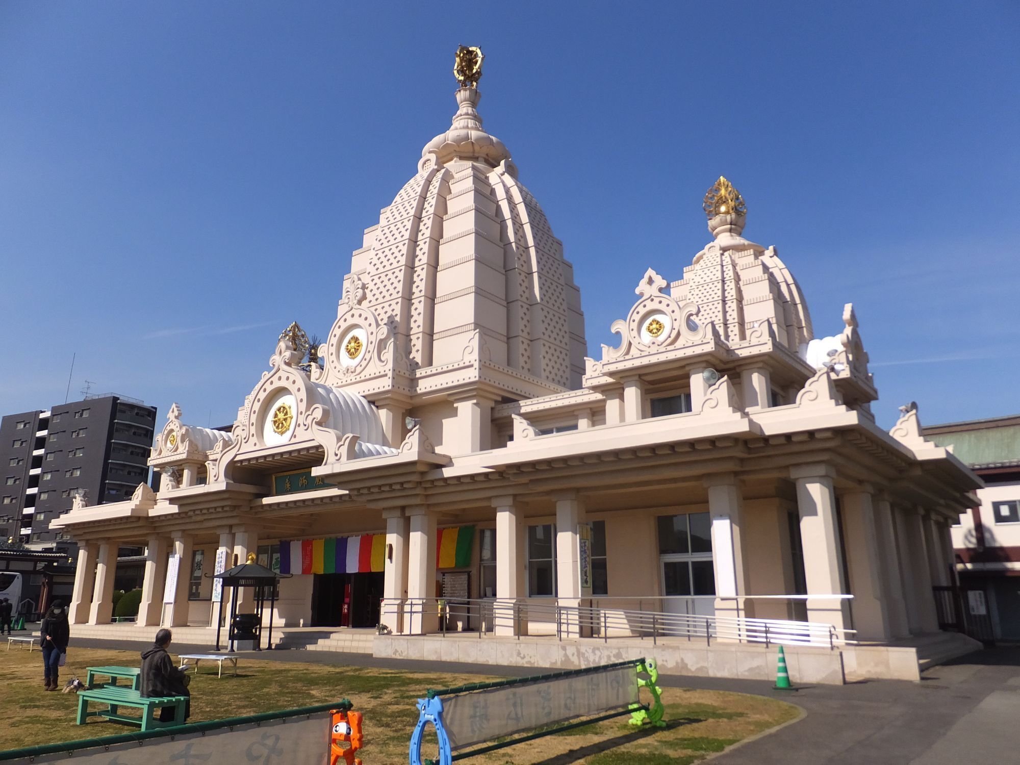 A large, ornate building with multiple domes and golden accents.