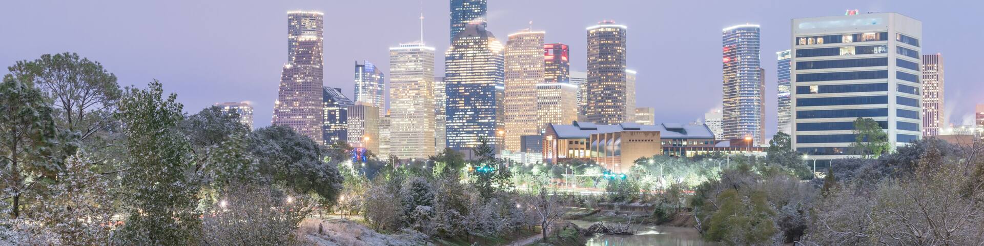 Panorama view unusual snowfall along Bayou River bank with downtown Houston, Texas, USA skylines city lights reflection at sunrise/twilight. Snow is extremely rarely and happen only 35 time since 1895