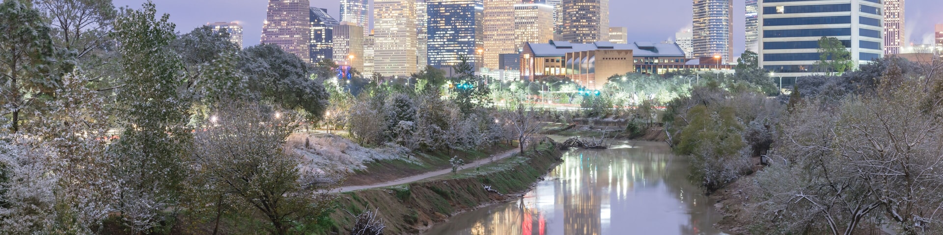 Panorama view unusual snowfall along Bayou River bank with downtown Houston, Texas, USA skylines city lights reflection at sunrise/twilight. Snow is extremely rarely and happen only 35 time since 1895