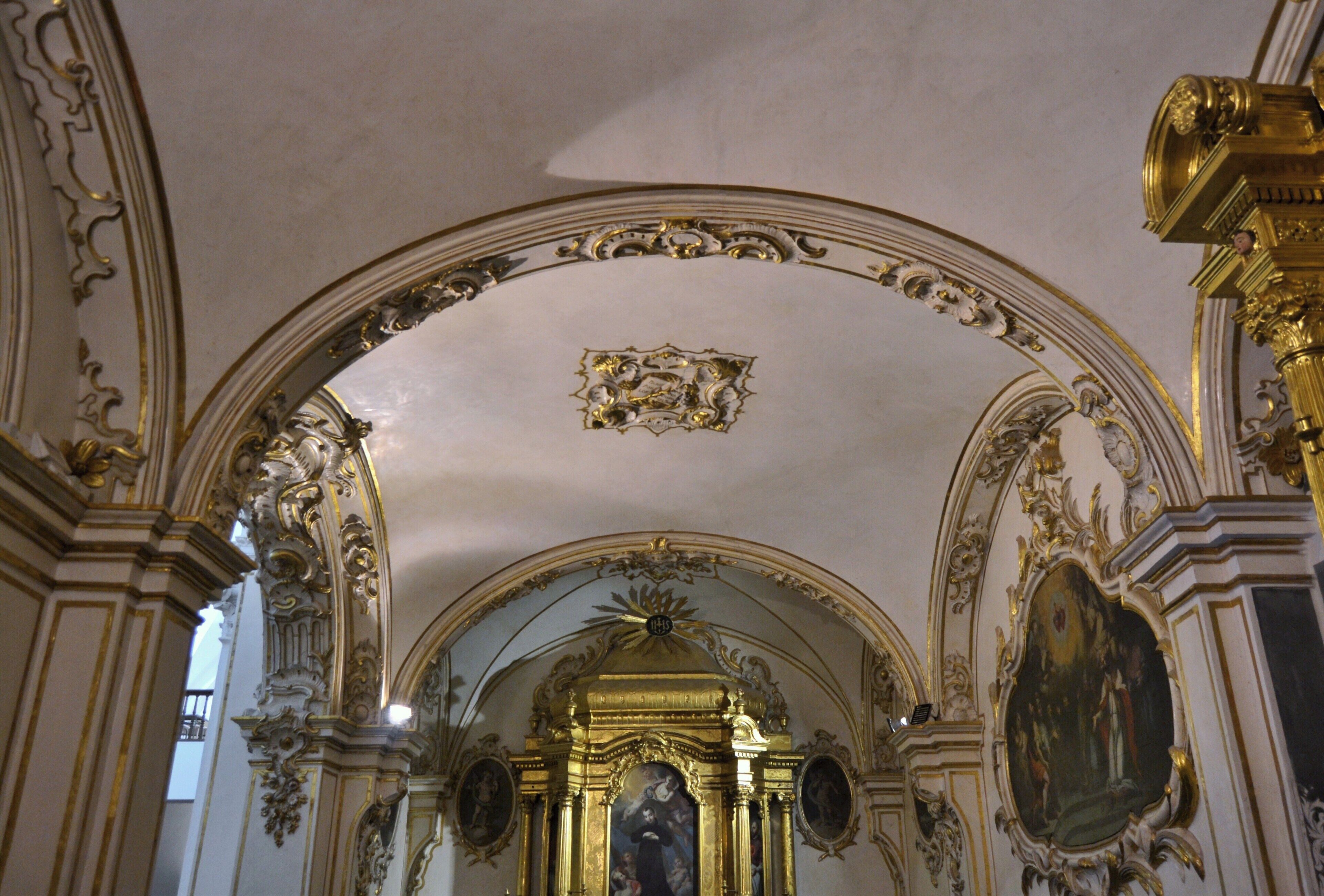 Un interior ornamentado con detalles dorados y frescos detallados.