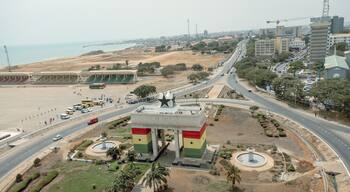 Aerial view of the iconic Black Star Gate arching proudly against the skyline with roads bustling with cars, Osu Klottey, Greater Accra Region, Ghana.