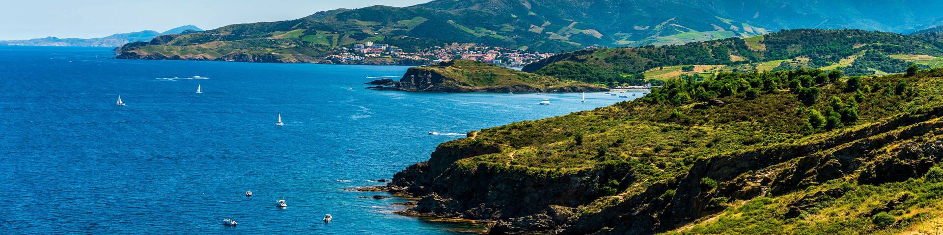 Steep coast of Roussillon, and in the background the village of Banyuls sur mer, in French Catalonia in Occitanie, France
