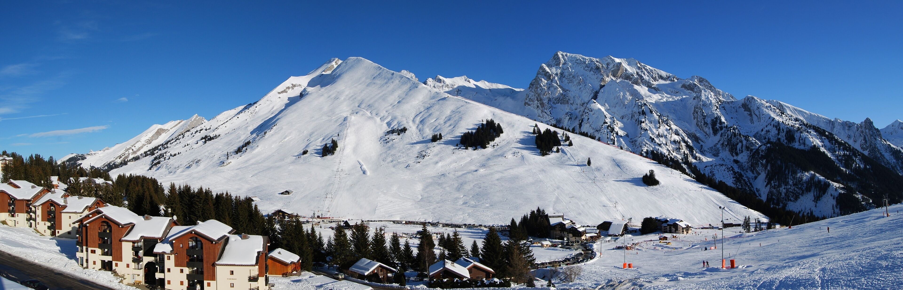 A snow-covered mountain with ski slopes and lodges.