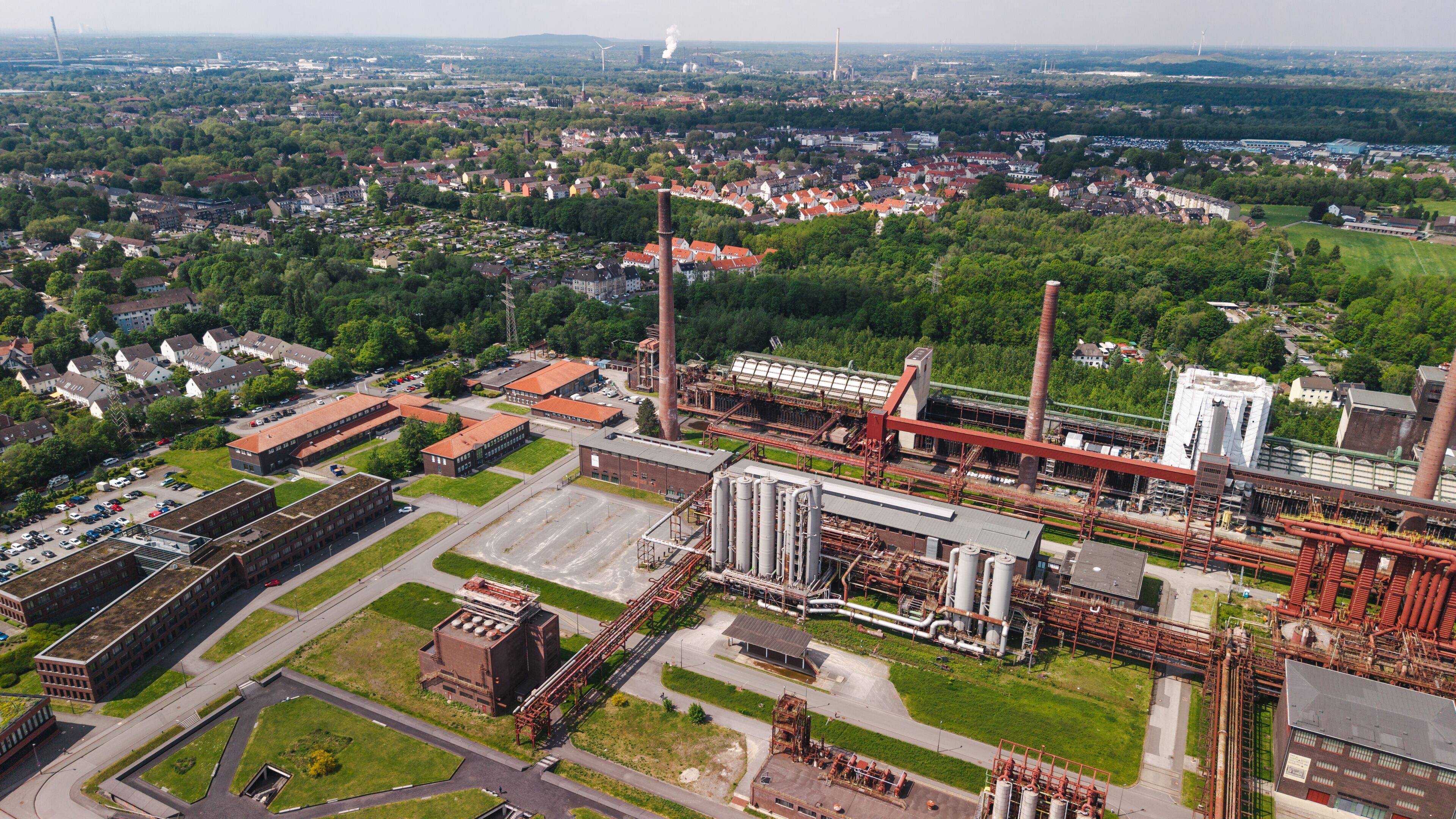 Aerial panorama of Zollverein Coal Mine Industrial Complex in Essen surrounded by urban district and green landscape in Germany