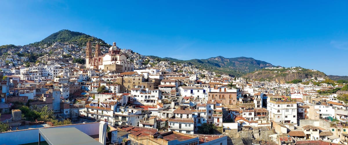 Mexico, Scenic panoramic view of Taxco historic center with colonial houses on the hills and famous Church of Santa Prisca de Taxco