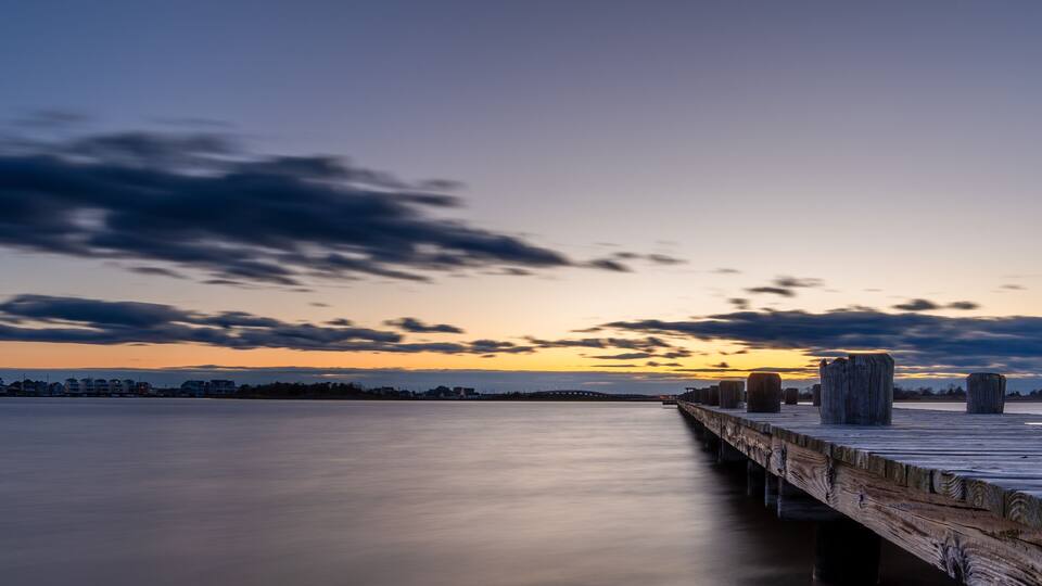 The sky is a beautiful shade of blue with a few clouds scattered throughout on the Barnegat Bay in New Jersey.