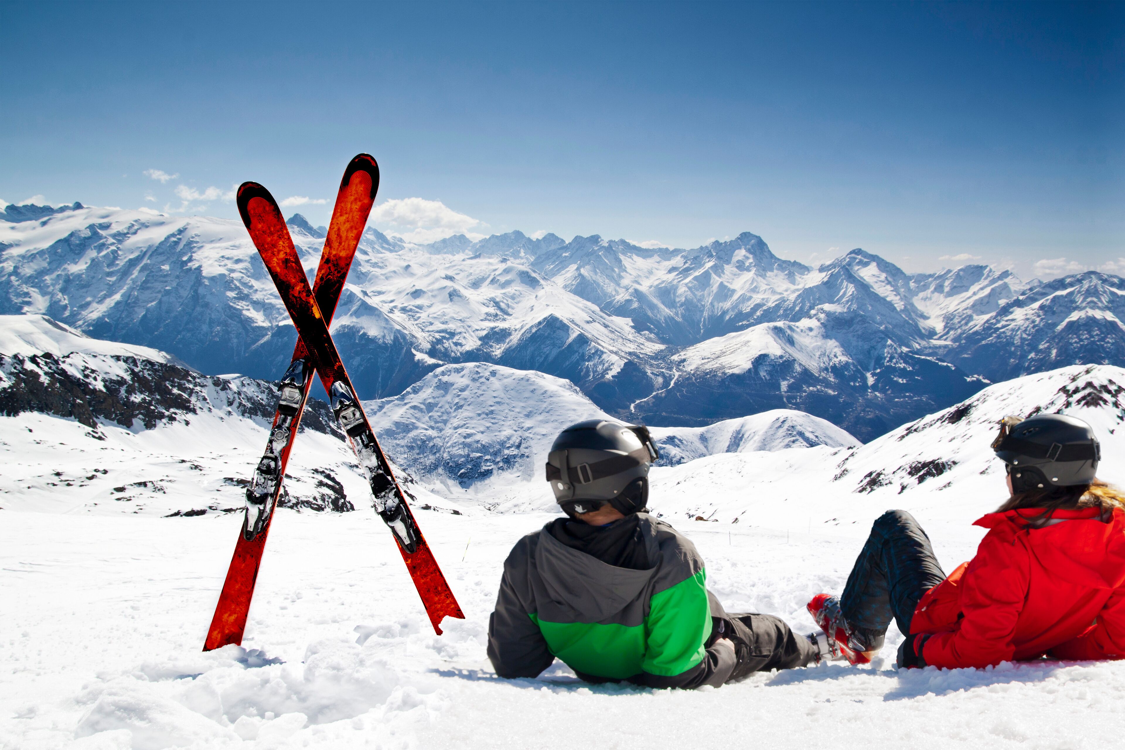 Young happy couple lying in snowy mountains