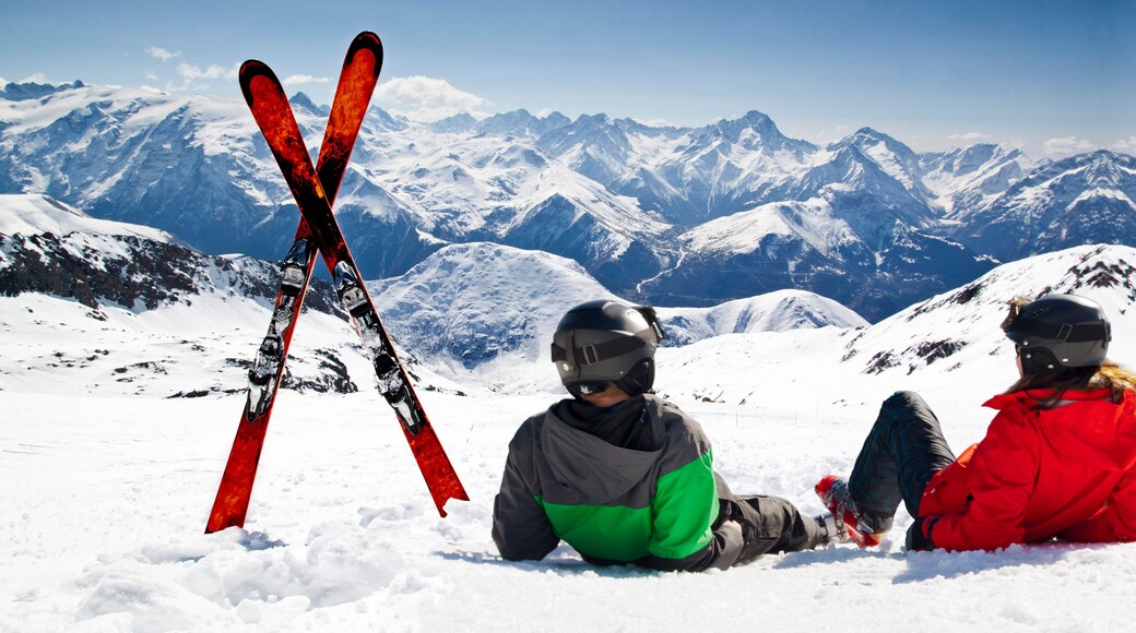Young happy couple lying in snowy mountains