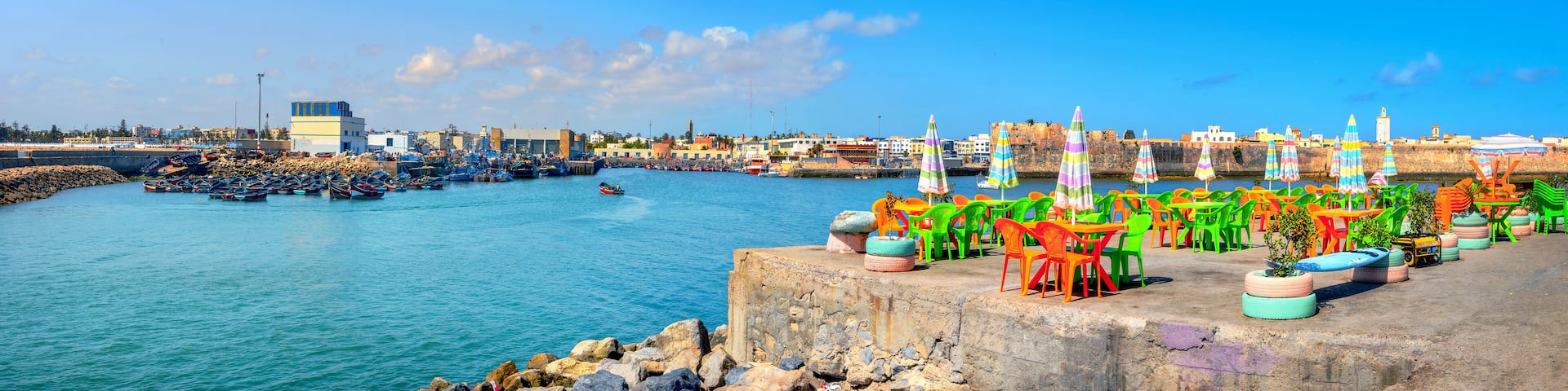 Landscape with colorful street cafe on quay of fishing port at Essaouira. Morocco, North Africa