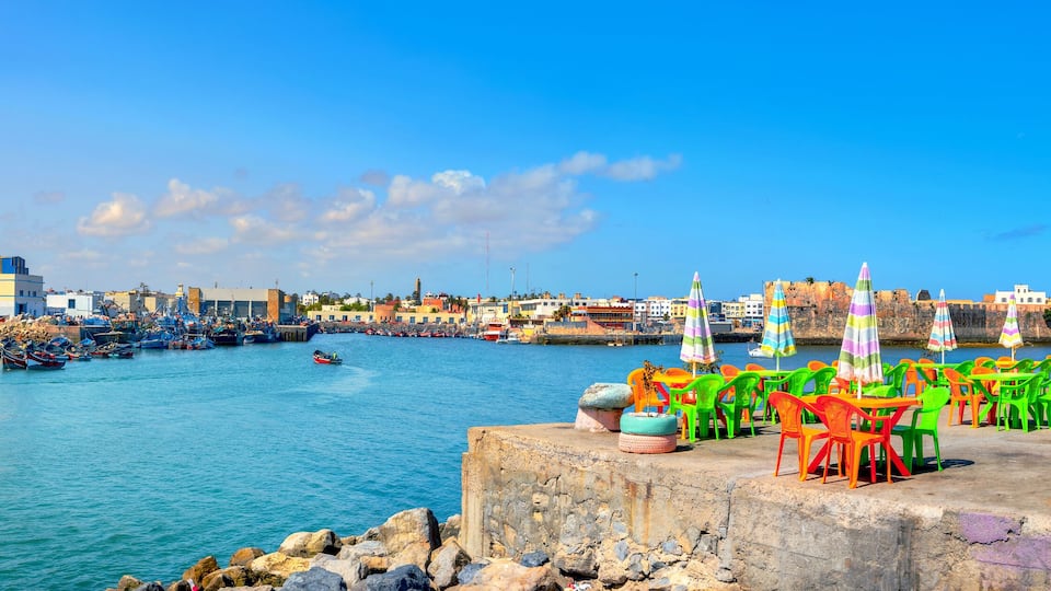 Landscape with colorful street cafe on quay of fishing port at Essaouira. Morocco, North Africa