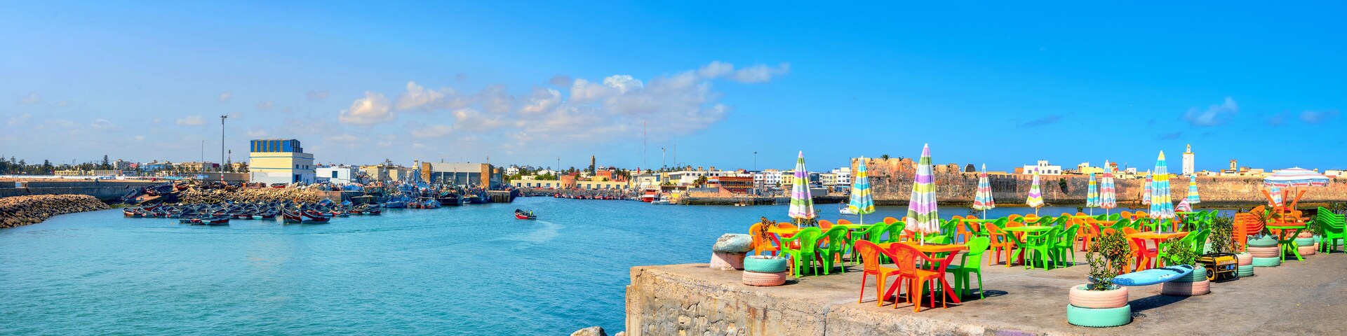 Landscape with colorful street cafe on quay of fishing port at Essaouira. Morocco, North Africa