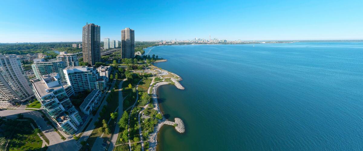 Artistic creative view of Humber Bay Shores Park city view and green space with skyline cityscape, azure lake Ontario. Skyscrapers over The Queensway on sunset at summer, Etobicoke, Ontario, Canada