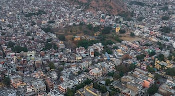 Aerial view of Ganesh Ji Temple surrounded by vibrant buildings and hills, Subhash Nagar, Jaipur, Rajasthan, India.