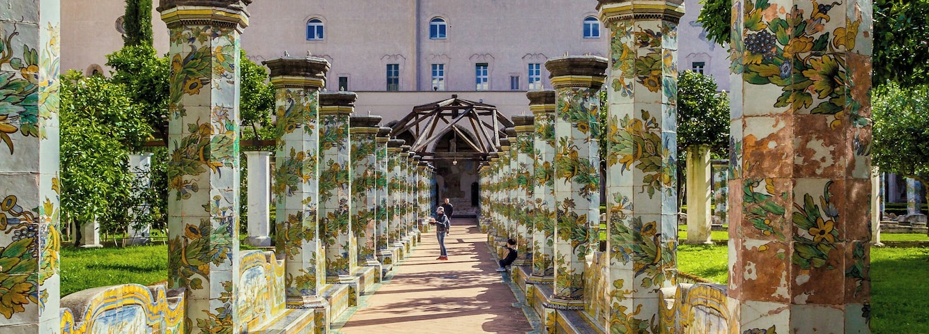 Un camino bordeado por columnas ornamentales que conduce a un edificio.