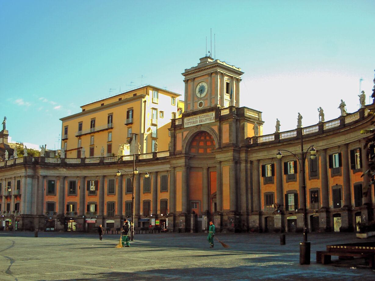 A historic square with a prominent clock tower and classical architecture.