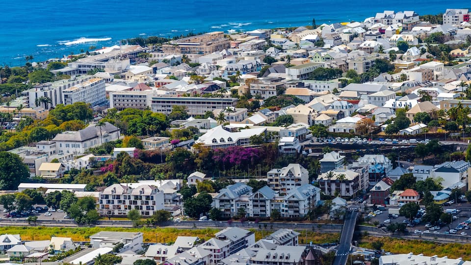Una cittadina costiera con edifici fitti, una spiaggia e una vista limpida sull'oceano.