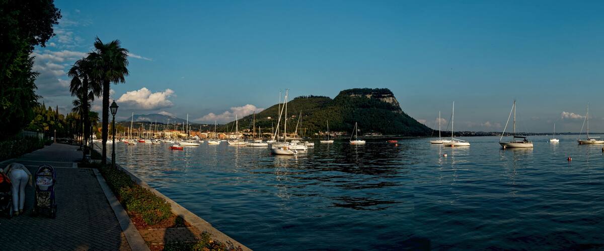 A harbor with boats, a mountain, and a coastal town.
