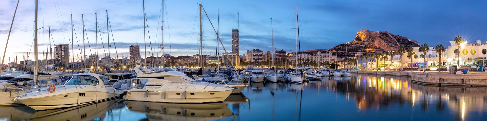 Alicante Port d'Alacant marina with boats and view of castle Castillo twilight travel traveling holidays vacation panorama in Spain