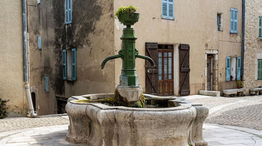 The village of Mons in the country of Calian. Medieval village in the South of France. A square in the center of the village. An old cast iron fountain above a round stone basin.