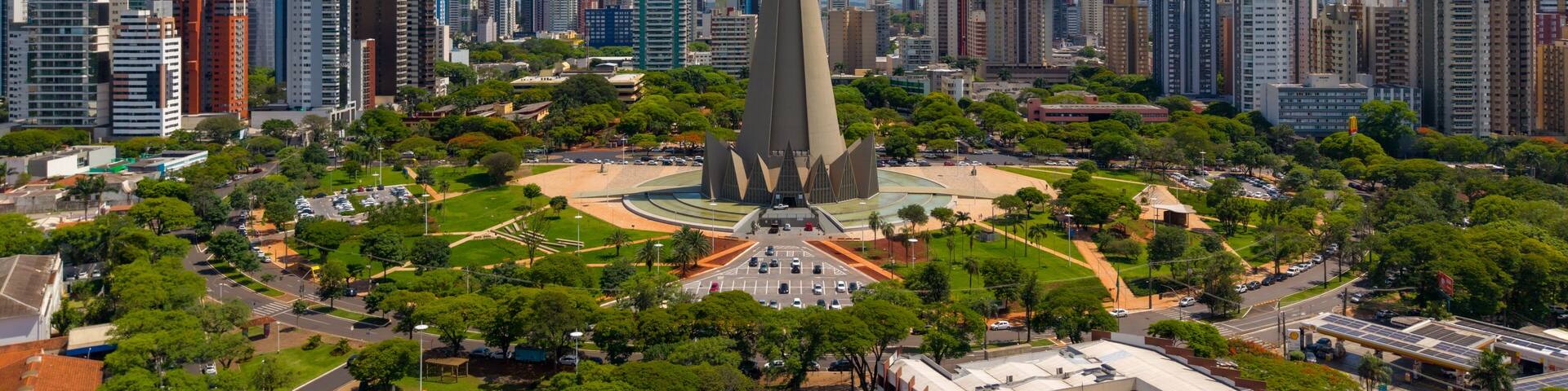 A cityscape with a prominent church spire, surrounded by modern high-rise buildings and lush green parks.
