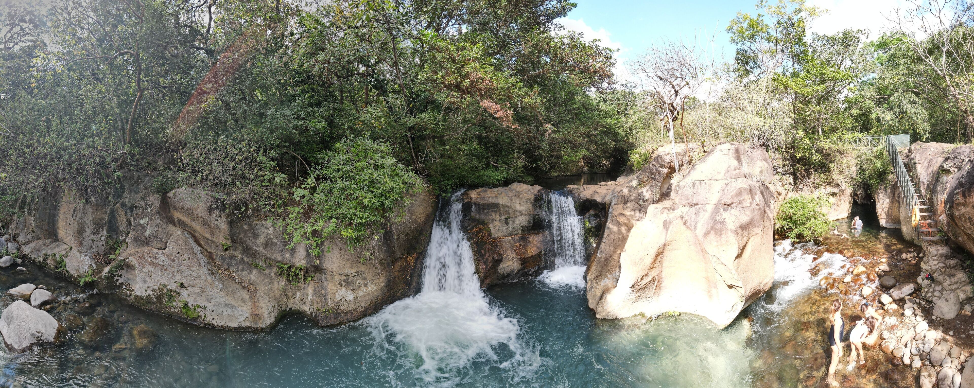 A waterfall cascading over rocks in a forested area.