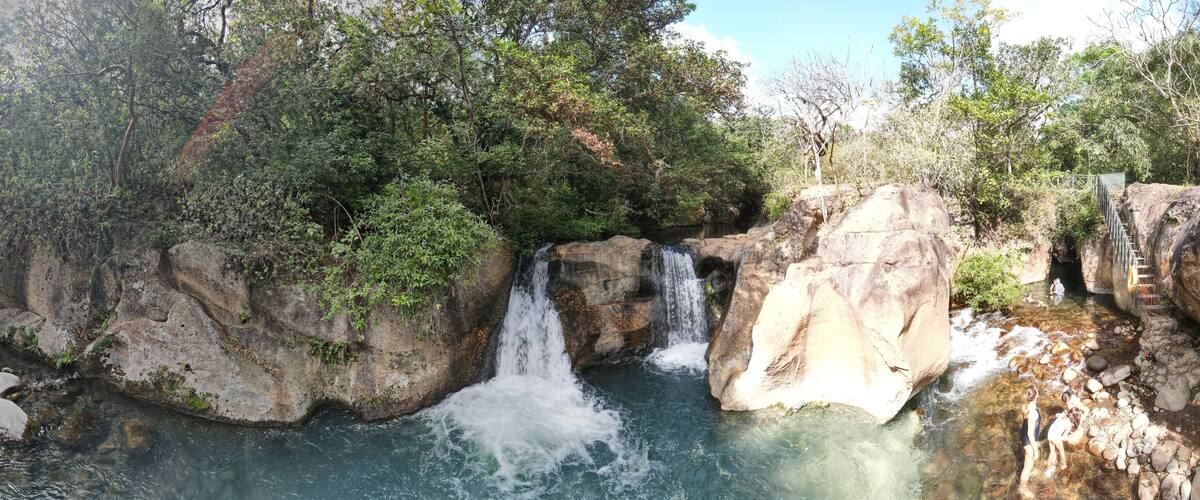 A waterfall cascading over rocks in a forested area.
