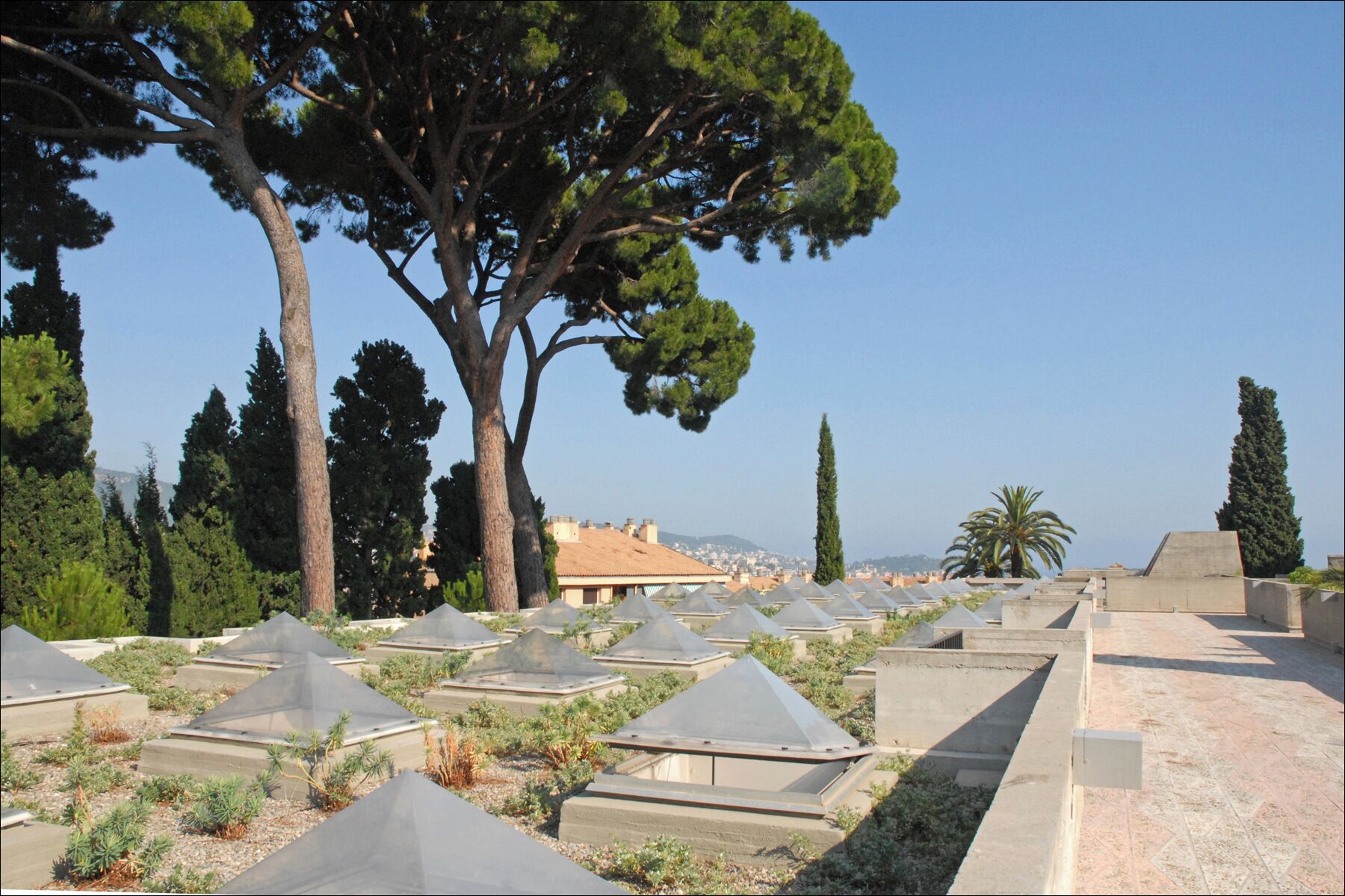 Les terrasses de la villa Arson Architecte Michel Marot et partenaires Nice Article de Wikipedia sur l'architecte fr.wikipedia.org/wiki/Michel_Marot_%28architecte%29 ______________ La villa Arson a été édifiée au XVIIIème siècle sur un domaine agricole de plus de 6 hectares sur la colline Saint-Barthélemy à Nice. Des jardins d'agrément ont été par la suite réalisés sur trois terrasses successives. Après le don du domaine par la ville de Nice à l'Etat en 1965, Il a été décidé d'y construire un centre d'art contemporain, une école d'art et une résidence pour des artistes. La conception du nouveau bâtiment a été confiée en 1968 à l'agence Michel Marot et Associés (Paris) qui s'est adjoint les compétences de Pierre Allar (Nice) Michel Marot a construit 17.000 m2 de bâtiments, sur une parcelle de forte déclivité de 23.000 m2, en tenant compte scrupuleusement de toutes les caractéristiques du site : présence de la villa ancienne, jardin en terrasse sur trois niveaux, arbres à préserver. Cette architecture complexe, (une présentation multimédia 3D est proposée sur le site), a été qualifiée de village, avec des places, des ruelles, des lieux de rencontres, d'étude, de travail, des patios et jardins, des terrasses, etc. Elle favorise le dialogue avec le paysage et grâce à la végétation les bâtiments sont particulièrement bien intégrés au site naturel. Le matériau utilisé en priorité est le béton resté brut, décoré dans certaines parties avec des galets du Var. C'est ce traitement qui a conduit à qualifier cette architecture de "brutaliste". La mauvaise qualité du béton utilisé (la construction a été effectuée à l'époque où Jacques Médecin était la maire de Nice) a posé très rapidement des problèmes d'étanchéité des bâtiments et des dalles en terrasses. D'importants travaux de réhabilitation ont eu lieu à la fin de la décennie 2000 et la végétation a été replantée. La villa Arson est redevenue un lieu exceptionnel d'architecture du XXème siècle. Site de la villa Arson www.villa-arson.org/