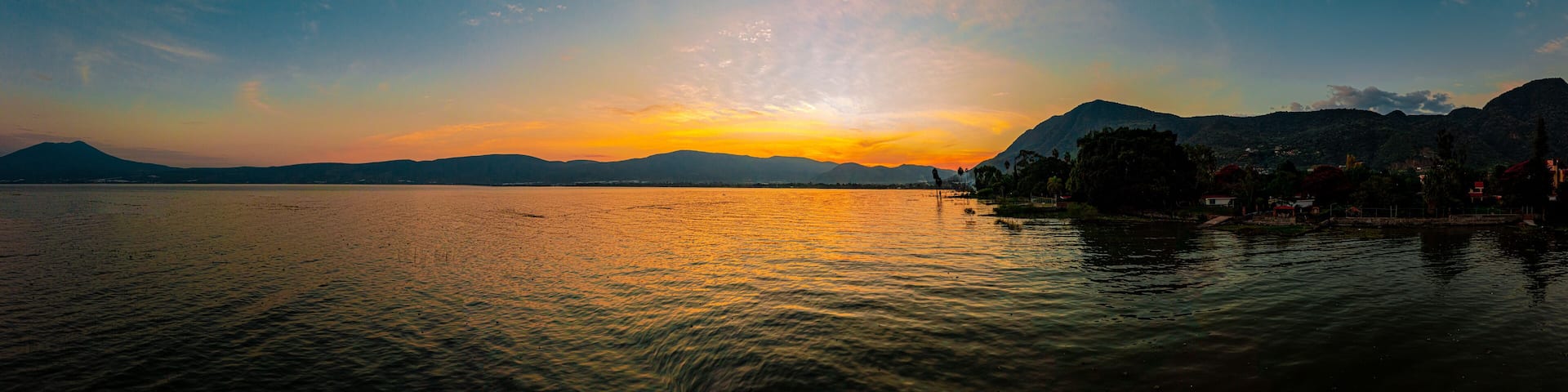 Sunset over a lake with clouds and colors in the sky. A lake from Mexico named Chapala.