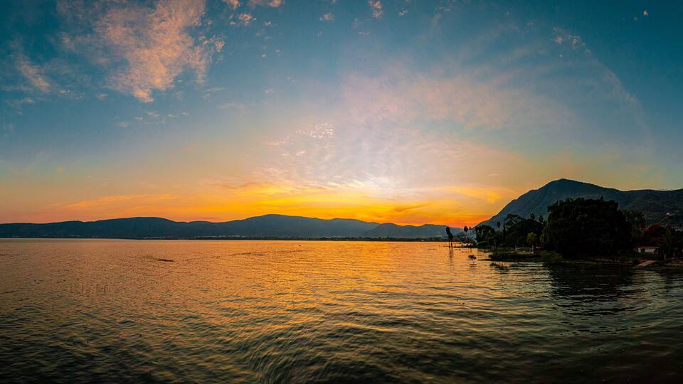 Sunset over a lake with clouds and colors in the sky. A lake from Mexico named Chapala.