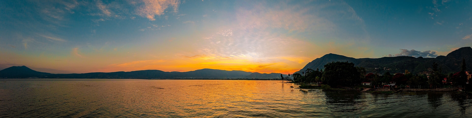 Sunset over a lake with clouds and colors in the sky. A lake from Mexico named Chapala.