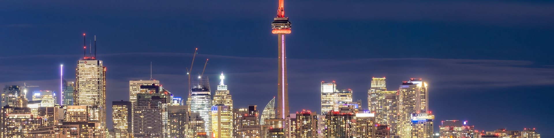Toronto, Canada - March 7, 2023 : The Glowing Toronto skyline lit up at night over Lake Ontario