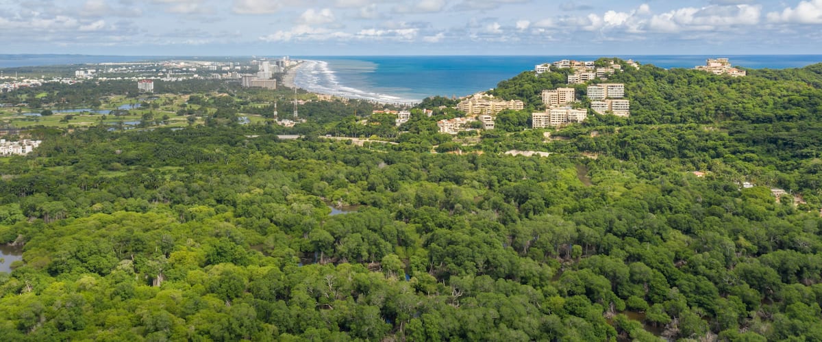Vista aérea de Acapulco Diamante, en Guerrero, Mexico. El drone sobre Cabo Marqués con un espectacular cielo azul como fondo