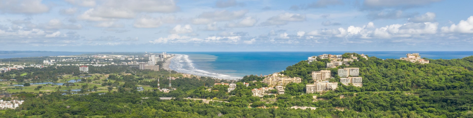 Vista aérea de Acapulco Diamante, en Guerrero, Mexico. El drone sobre Cabo Marqués con un espectacular cielo azul como fondo