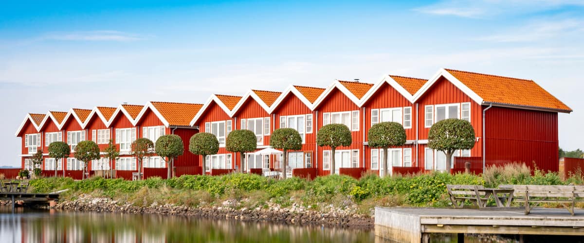 Rote Häuser am Hafen von Ebeltoft, die sich im Wasser spiegeln, horizontal, Langzeitbelichtung