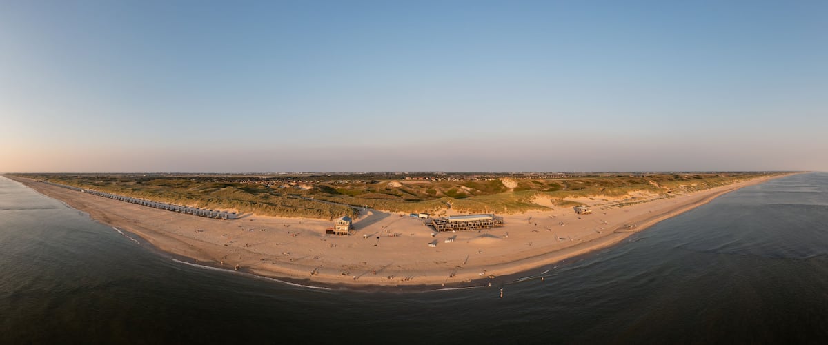 Luftaufnahme, Grosser Panoramablick auf den Strand, den Deich und den Ort Julianadorp aan Zee mit Wolken am Himmel, Den Helder, Nordholland, Niederlande