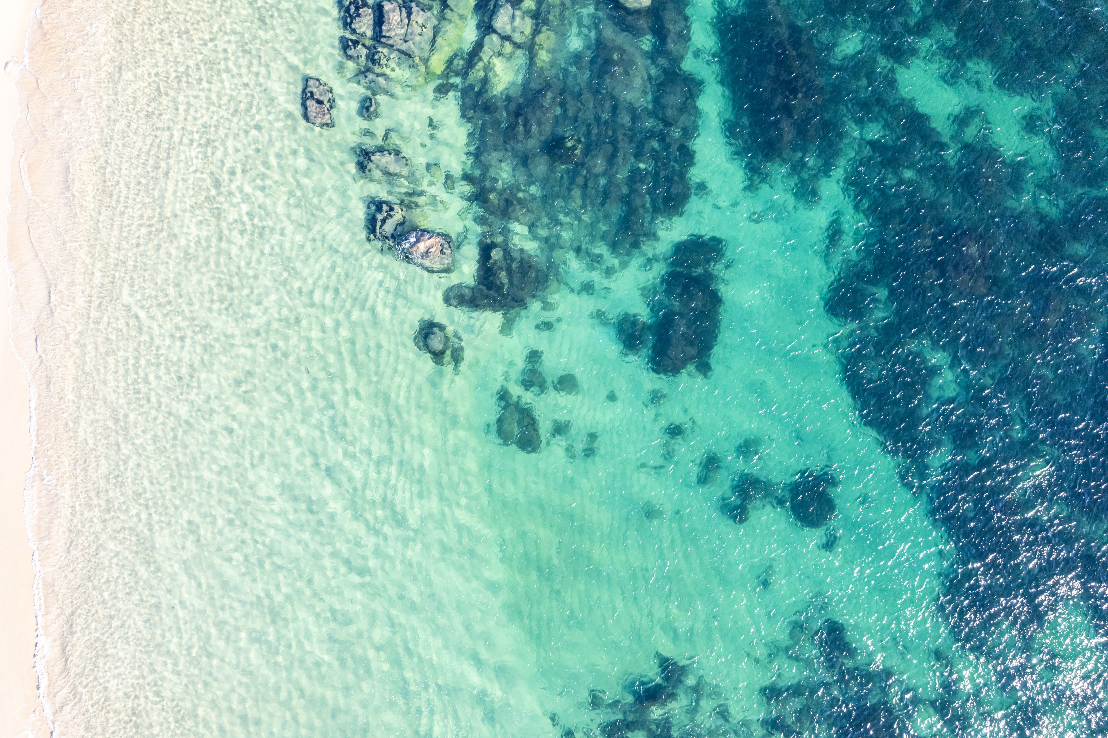 turquoise and clean water of the sea on the shore of a beach in the Rias Baixas in Galicia. Spain. Aerial zenithal drone view