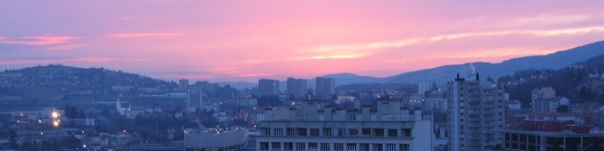 Quartier Châteaucreux de Saint-Etienne, Loire, à l'aube depuis colline du Crêt de Roc. Visible à l'image une institution locale, ayant essaimé à l'international: à droite ancien siège du groupe de distribution Casino de 1976 à 2007, situé bas rue de la Montat. Il était relié aux bureaux historiques par une passerelle enjambant l'artère; sur la gauche migrant en 2008 une centaine de mètres au nord Esplanade de France, nouveau quartier général face au parvis de la principale gare stéphanoise.