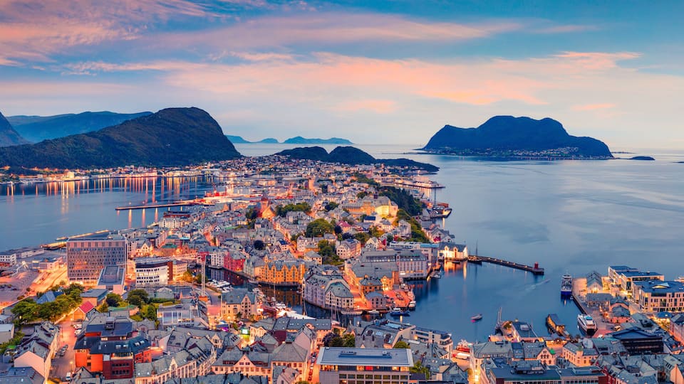 From the bird's eye view of Alesund port town on the west coast of Norway, at the entrance to the Geirangerfjord. Colorful sunset in the Nord. Traveling concept background.