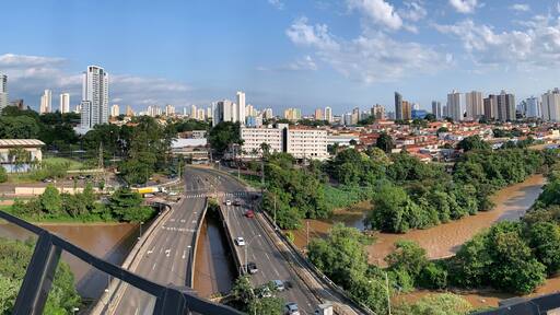 A river flowing through a city with high-rise buildings and a bridge.