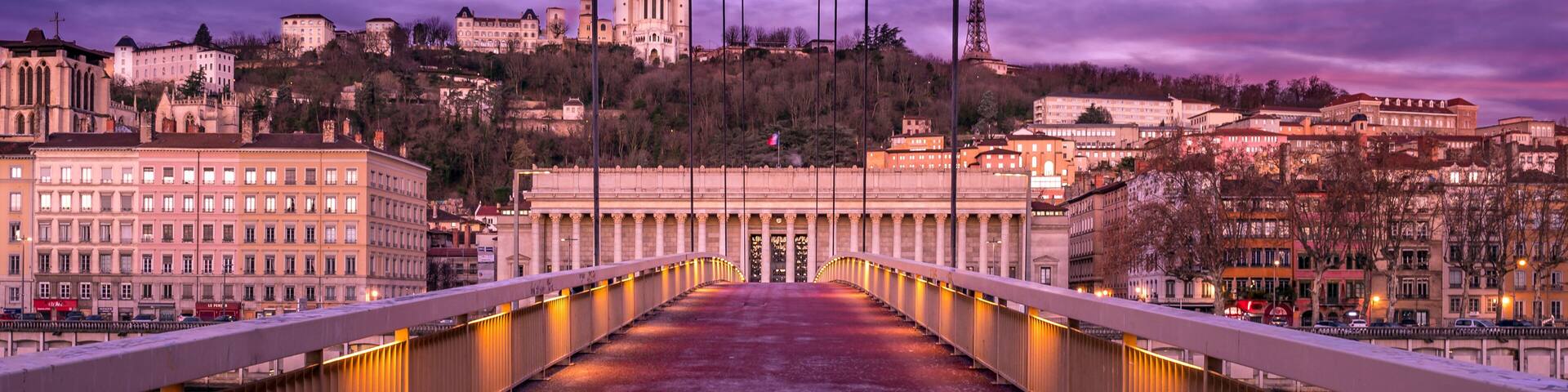 A bridge with a view of a cityscape, including a prominent cathedral and the Eiffel Tower in the background.
