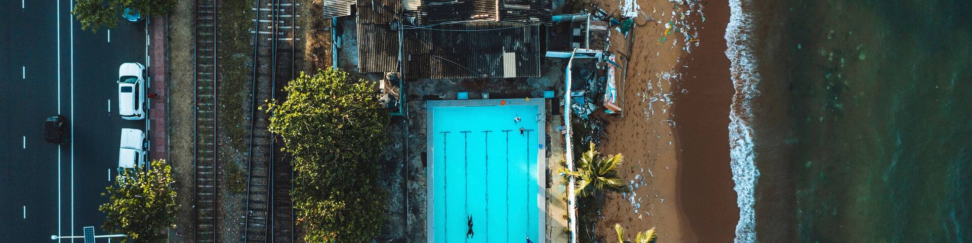 Aerial top down view of public open air swimming pool on the beach in Wellawatte district, Colombo city, Sri Lanka.
