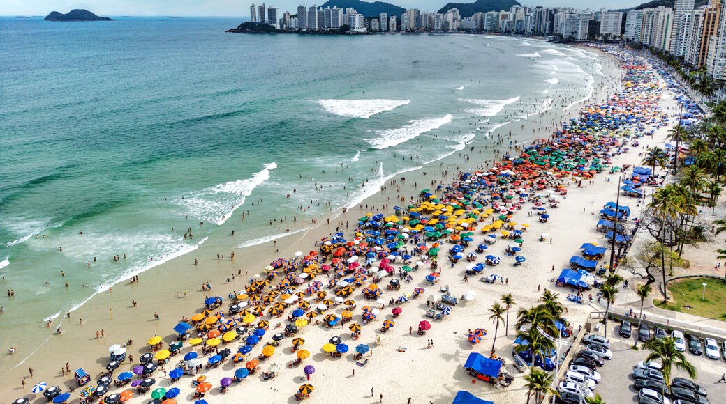 Vista aérea de dia ensolarado com muitos turistas na Praia de Pitangueiras no litoral paulista, Guarujá.