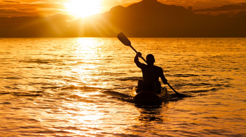 Silhouette of man at sunset paddling in his kayak on the coast of Brazil, Tabatinga beach in São Paulo.