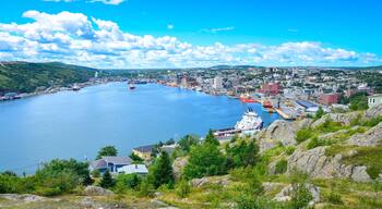 Panoramic views with bight blue summer day sky with puffy clouds over the harbour and city of St. John's Newfoundland, Canada.