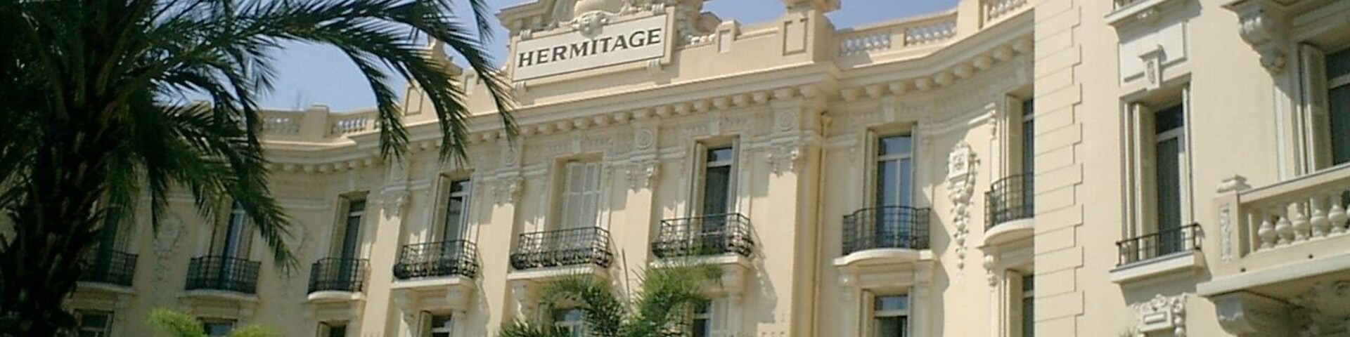 A classical building with the sign "HERMITAGE" and ornate balconies.