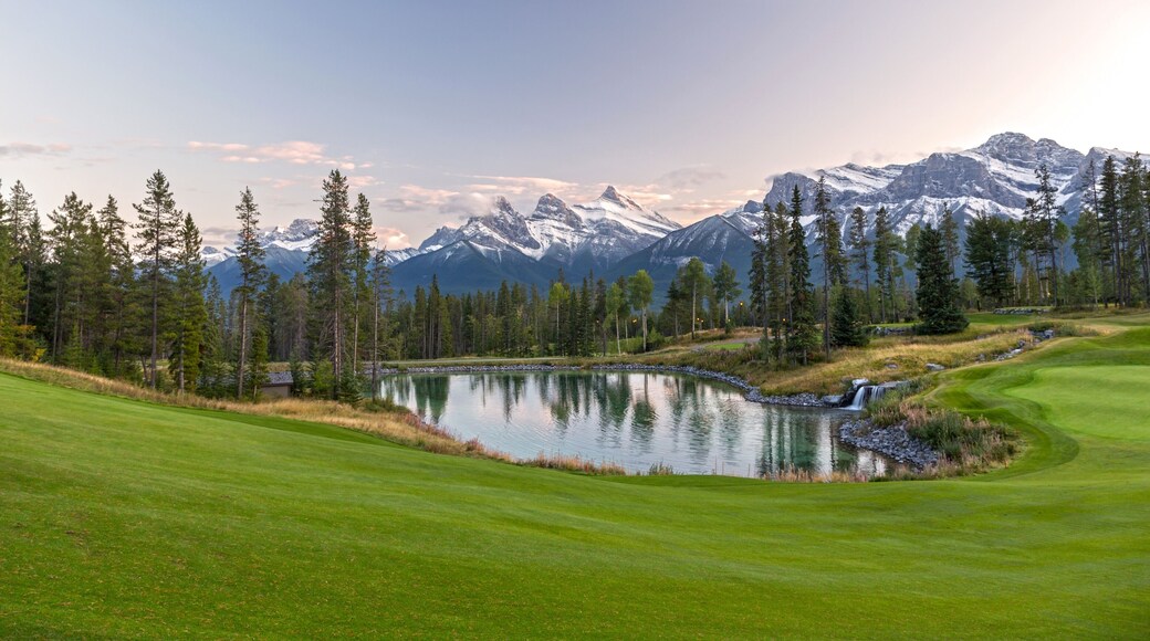 Silvertip Golf Course Green and Distant Landscape View of Three Sisters Snowy Mountain Tops above Town of Canmore in Foothills of Rocky Mountains Alberta Canada