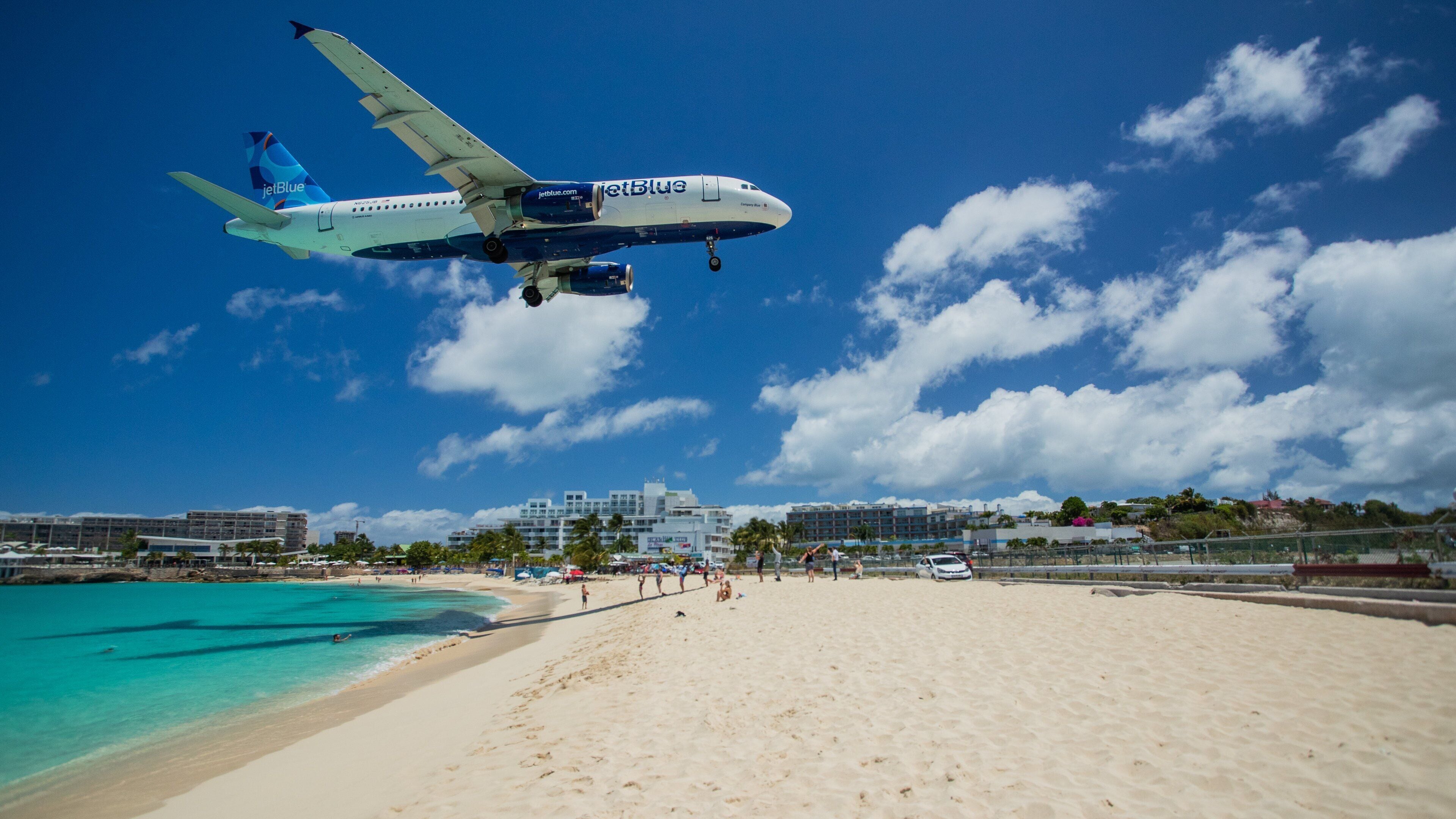Maho which includes general coastal views, a beach and aircraft